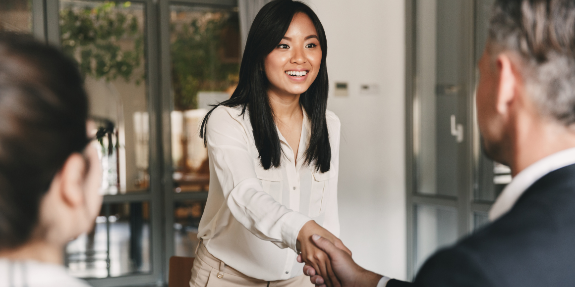 A woman shaking the hand of the man interviewing her