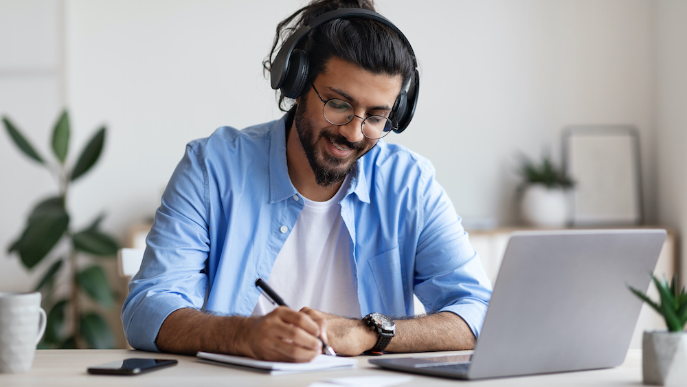 graduate student wearing headphones studying online